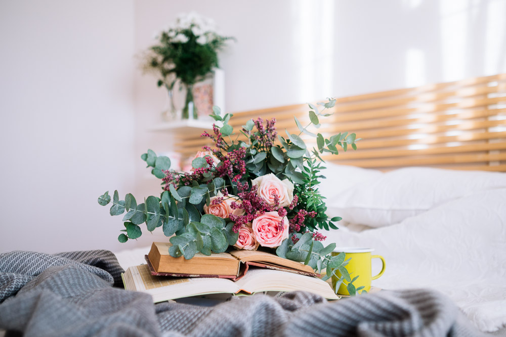 Books and Flowers Lying on Bed